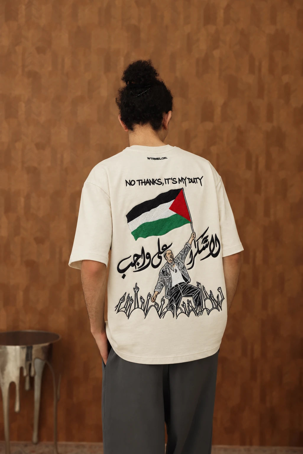 The Voice Off White T shirt on male model, back view with black embroidered lettering and hands, AI edited colourway visualization